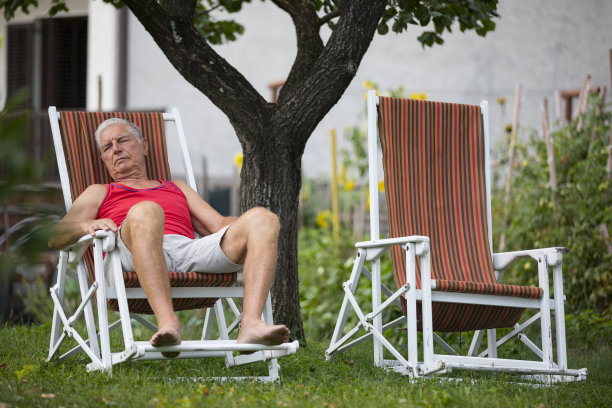 年长的成年人在后院的椅子上休息图片下载