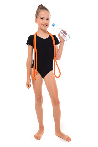 图片的女孩体操运动员在黑色trico全高度与跳绳绕她的脖子和一瓶水在一个白色的背景孤立图片下载