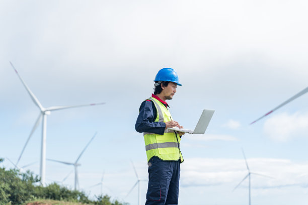 工程师检查风力发电站下面的工作图片下载