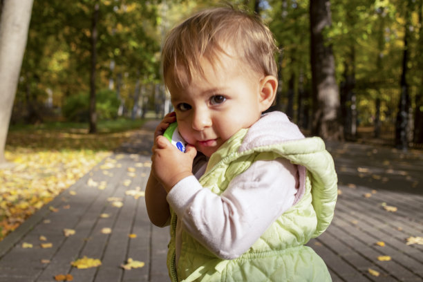 小商人。可爱的蹒跚学步的孩子玩玩具电话聊天的肖像。图片下载
