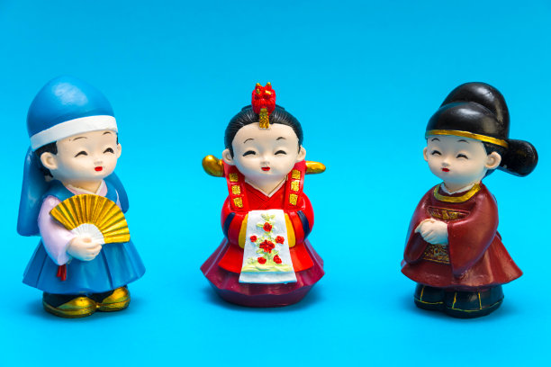 三个装饰陶瓷韩国人物在传统的彩色服装汉博克人物分配在绿松石的背景。收集。爱好和休闲。图片下载