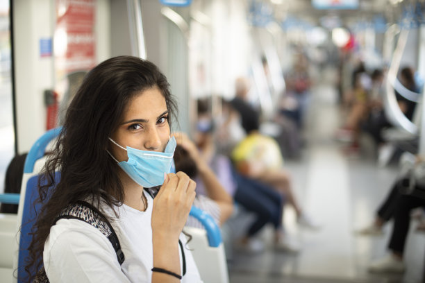 新冠病毒COVID-19预防传播概念：年轻女子在公共汽车上戴口罩，以防止污染和病毒，如冠状病毒图片下载