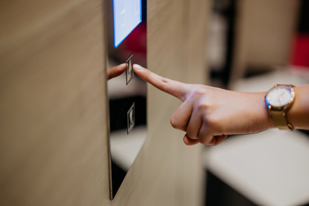 年轻的亚洲女人按电梯按钮图片下载