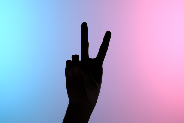 女性手举胜利和平标志，霓虹闪烁图片下载