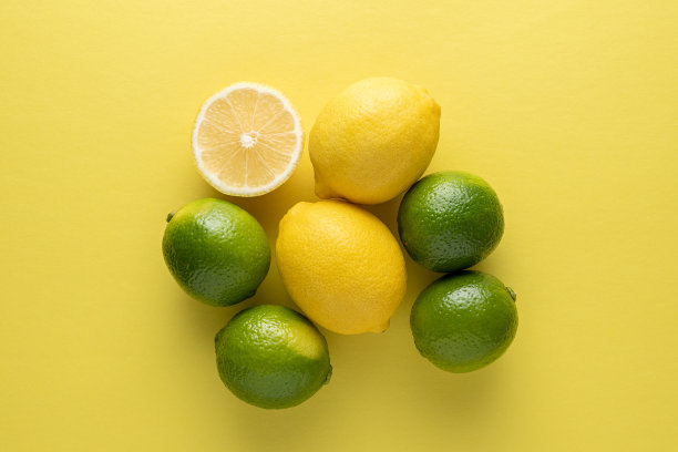 明亮的背景上放着酸橙和柠檬。夏天的概念。图片下载