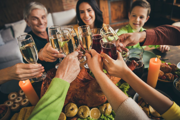 家庭亲戚见面的照片，坐，服务的餐桌，手握酒杯，金酒，炖水果收集后，长时间的离别多代晚上在客厅室内图片下载