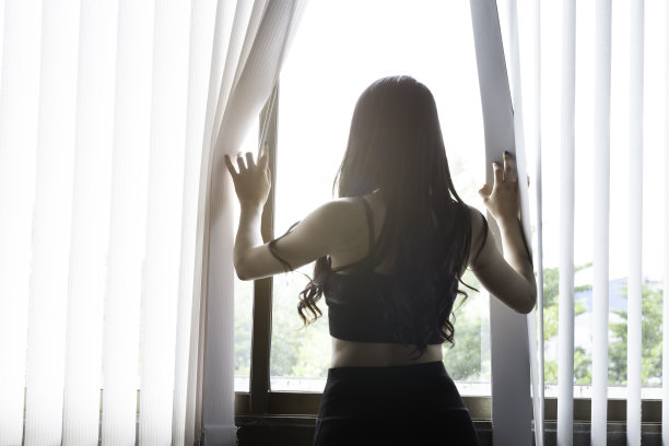 美丽的亚洲女人呆在房间看窗外练习瑜伽和训练锻炼。图片下载