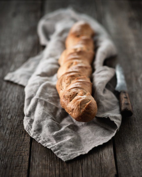 旧木桌上放着刚烤好的法式长棍面包图片下载