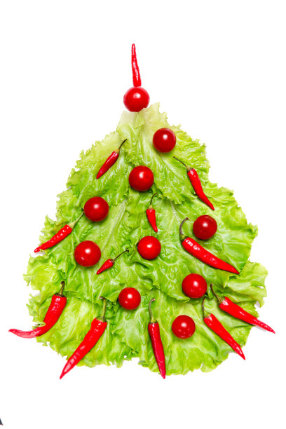 新年象征:用新鲜的绿色沙拉叶、圣女果和红辣椒在白色背景上做成的圣诞树。圣诞烹饪模型图片下载