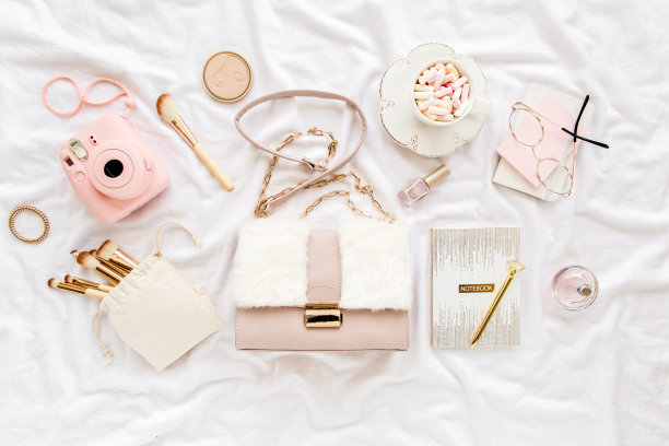 粉色手袋，相机，化妆刷，化妆品，太阳镜，白色背景的配件。平面构成。社交媒体。前视图。平躺图片下载