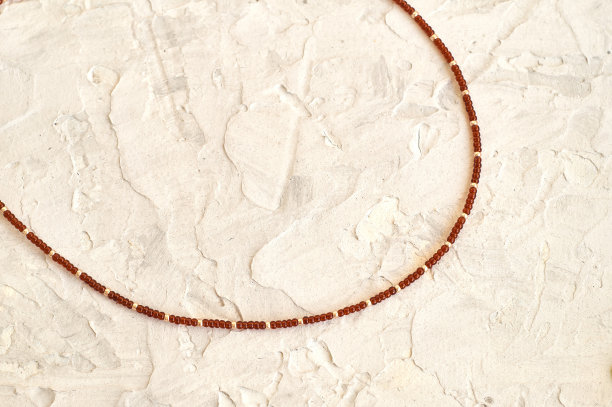 手工珠饰，作为一种爱好。用你自己的手在各种花的背景上制作的装饰品图片下载