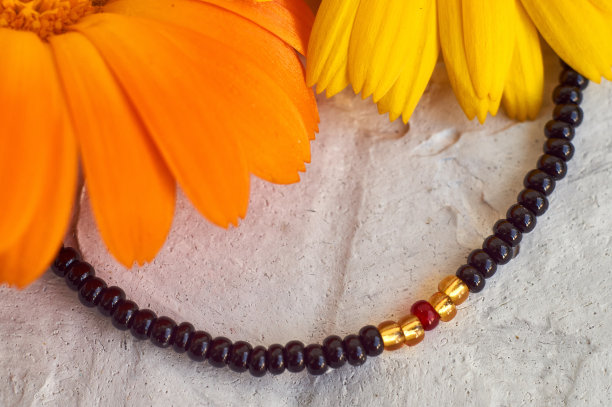 手工珠饰，作为一种爱好。用你自己的手在各种花的背景上制作的装饰品图片下载