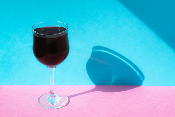 彩色背景下的一杯葡萄酒。明亮多彩的极简主义图片下载