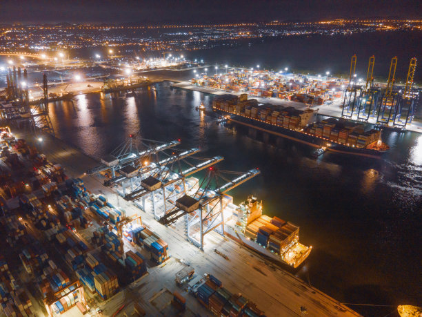 物流与运输的集装箱货轮和货机与工作起重机桥在日出船厂，物流进出口和运输行业背景图片下载