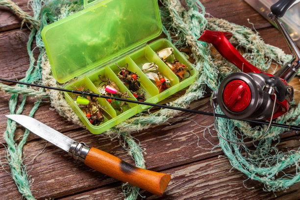 不同的钓具与杆和卷轴上的木制棕色背景。广告和出版的Mockap。图片下载