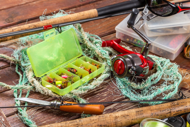 不同的钓具与杆和卷轴在木棕色的背景。广告和出版Mockap。图片下载