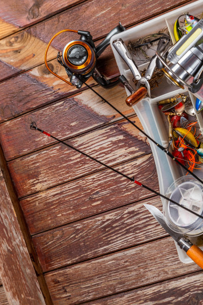 不同的钓具与杆和卷轴上的木制棕色背景。广告和出版的Mockap。图片下载