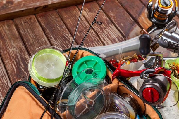 不同的钓具与杆和卷轴在木棕色的背景。广告和出版Mockap。图片下载