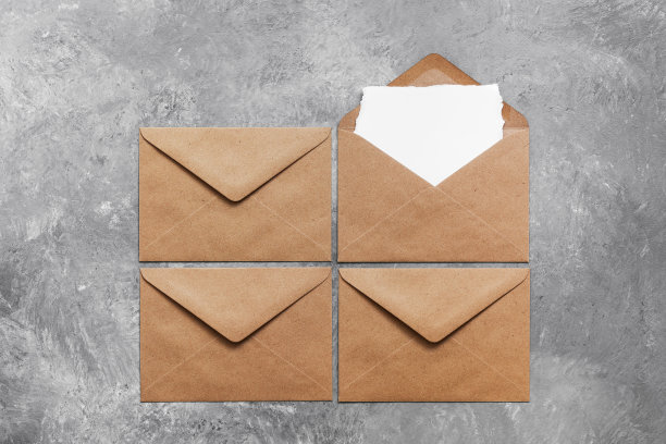 空白邀请卡模型在工艺信封在灰色混凝土背景。现代文具简约静物。俯视图，平放图片下载