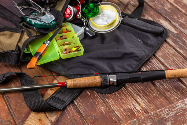 不同的钓具与杆和卷轴在木棕色的背景。广告和出版Mockap。图片下载