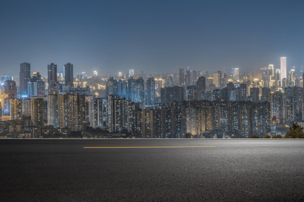 空旷的混凝土地面在市中心与照明的现代城市景观和建筑物在晚上。图片下载