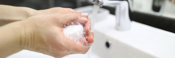 特写男子在水龙头下用肥皂洗手图片下载