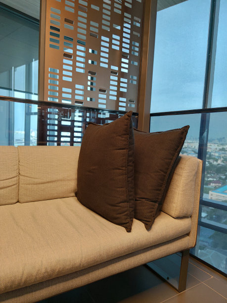 舒适的角落装饰皮革皮色沙发与枕头的房子客厅和发光拥挤的城市，装饰背景图片下载