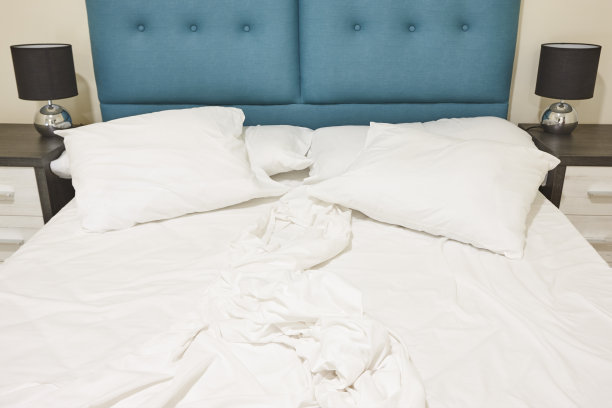 有未整理的双人床的卧室。公寓内部图片下载