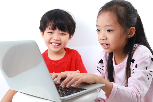 快乐的兄弟姐妹共享使用笔记本电脑的白色背景图片下载