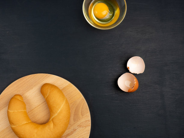 黑色木质背景上的糕点和鸡蛋。烹饪概念图片下载