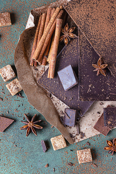 黑巧克力和牛奶巧克力块，香料，红糖，蛋白霜和棉花糖的混凝土背景。甜食照片的概念。前视图。图片下载