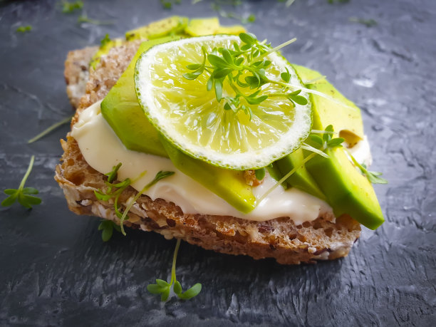 混凝土背景上涂着牛油果石灰的三明治图片下载