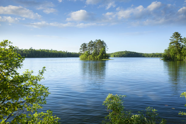 一个阳光明媚的下午，美丽的蓝色湖泊和一个岛屿在明尼苏达州北部中部图片下载