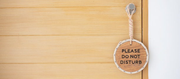 豪华酒店木门附近挂着“请勿打扰”的特写标志图片下载
