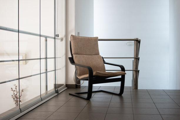 现代木制舒适的扶手椅坐在室内阳台地板上图片下载