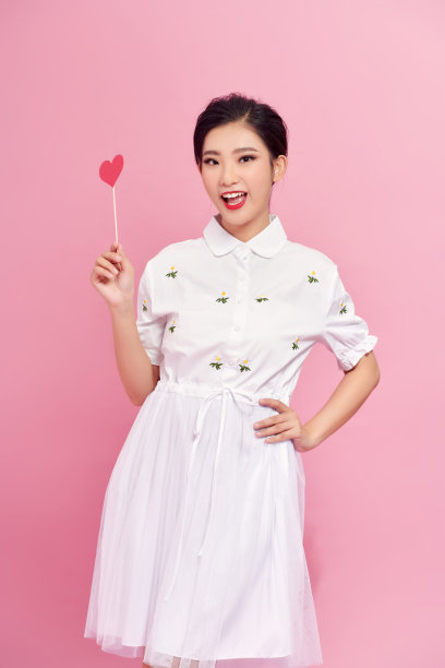 浪漫的年轻女子与派对装饰情人节在粉红色的背景图片下载