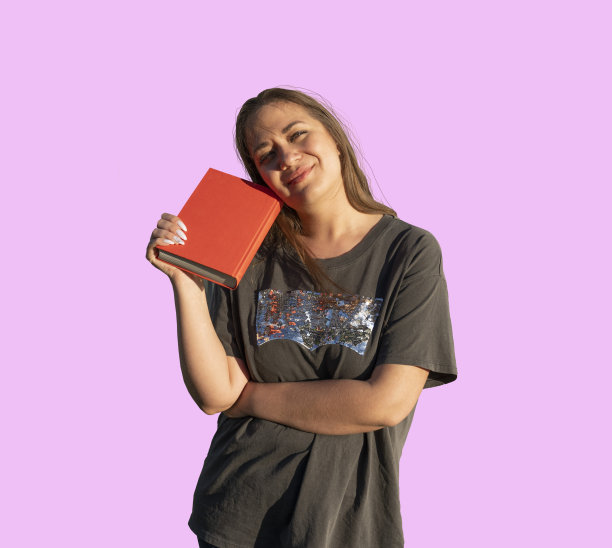 一张孤立的照片，一个年轻美丽的女孩与一本书，学习图片下载