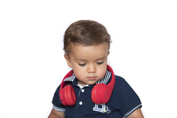 孩子用手机看视频，红色耳机和深蓝色衬衫图片下载