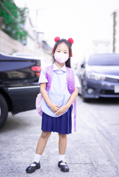 亚洲小女孩在上学前戴口罩，以抵御黄昏和COVID-19图片下载