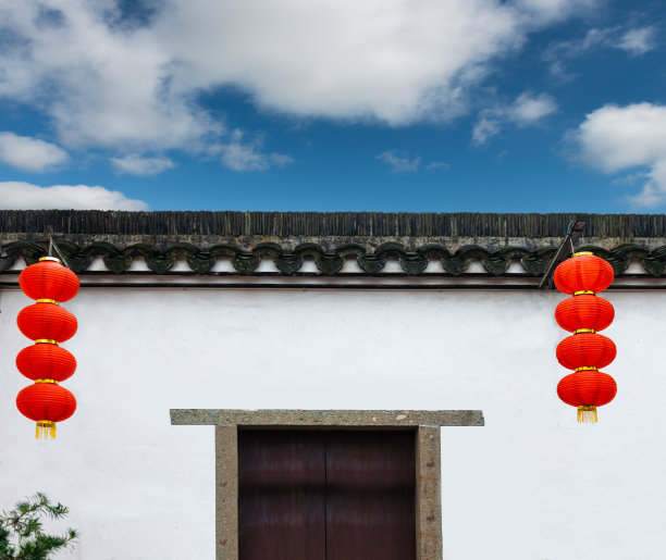 传统的中国建筑，白色的墙壁，石头框架门和红灯笼下的屋檐图片下载