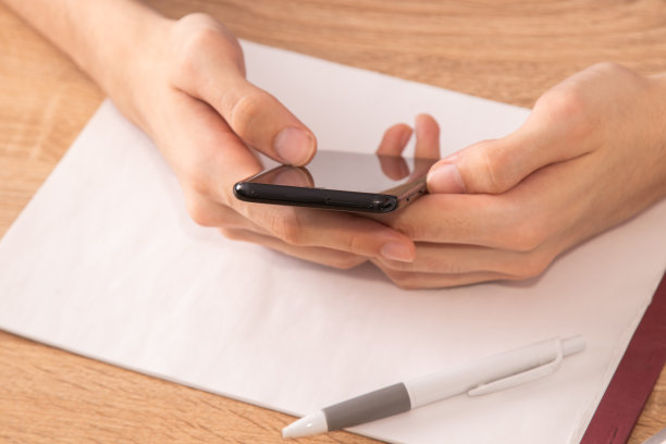 特写俯视图的手与手机在桌子上图片下载