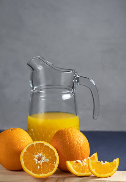 橙色和橙汁装在一个木架上，在灰色的背景，侧视图。图片下载