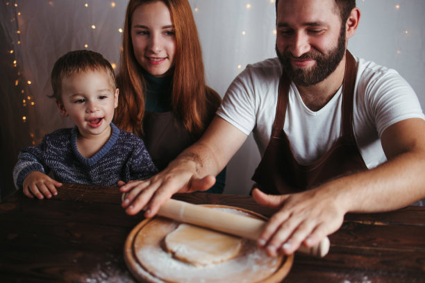 妈妈，爸爸和儿子在揉姜饼面团图片下载