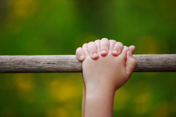 孩子的手紧紧抓住一根棍子的特写图片下载