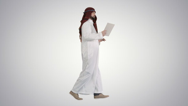 谢赫使用数码平板电脑，在渐变背景下行走图片下载