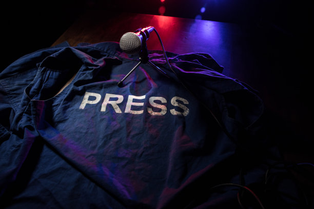 新闻自由和新闻概念。蓝色记者背心在黑暗中与背光和雾。有选择性的重点图片下载