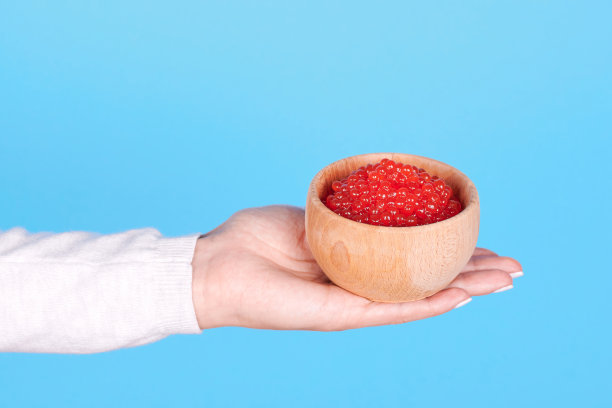 三文鱼鱼子酱，海鲜放在木罐上，孤立在蓝色背景上。图片下载