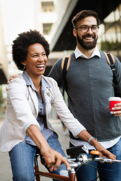 快乐的商业夫妇骑自行车通过城市和有乐趣图片下载