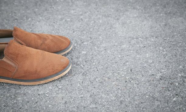 棕色鞋在沥青背景上。图片下载