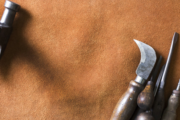 深红棕色麂皮工作围裙提供了一个合适的背景，一些古董工具，所有与木制把手。图片下载